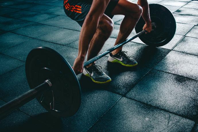 prueba de fitness guiado por genética Una persona levantando unas pesas, representación de la prueba de fitness guiado por genética